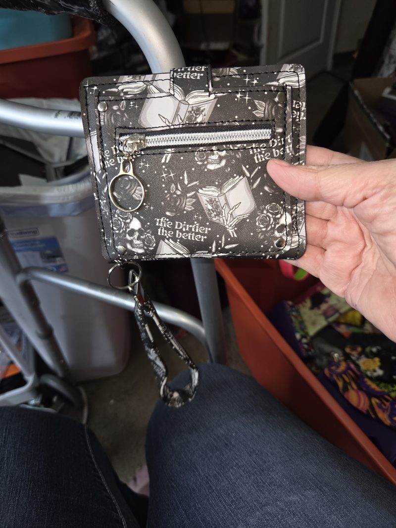 Back of gothic skull wristlet wallet with silver zipper pocket and detachable matching wrist strap