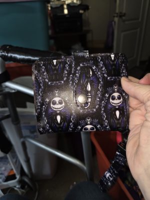 Handmade Jack Skellington-inspired wristlet wallet featuring black and purple gothic character print, silver-tone snap-tab closure and coordinating wrist strap.