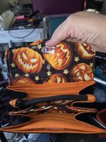 Open Halloween Pumpkin NCW Wallet with orange accordion compartments, pumpkin-print lining and black zippered pocket