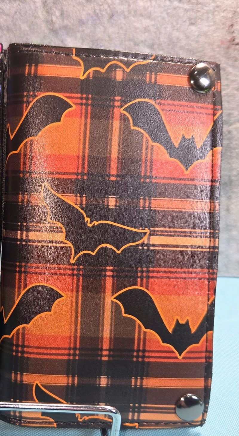 Handmade Mini Draco orange bat bifold wallet featuring black bat silhouettes on orange and black plaid with metal snap closures.