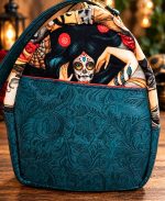 Side view of handmade sugar skull bowler bag with teal floral embossed vinyl