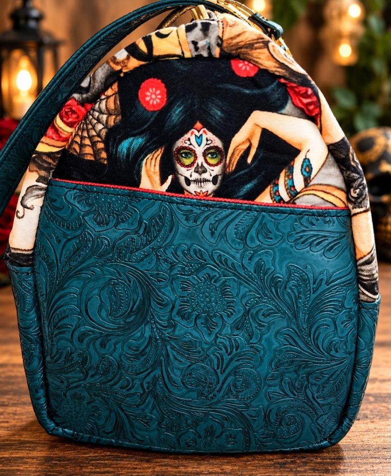 Side view of handmade sugar skull bowler bag with teal floral embossed vinyl