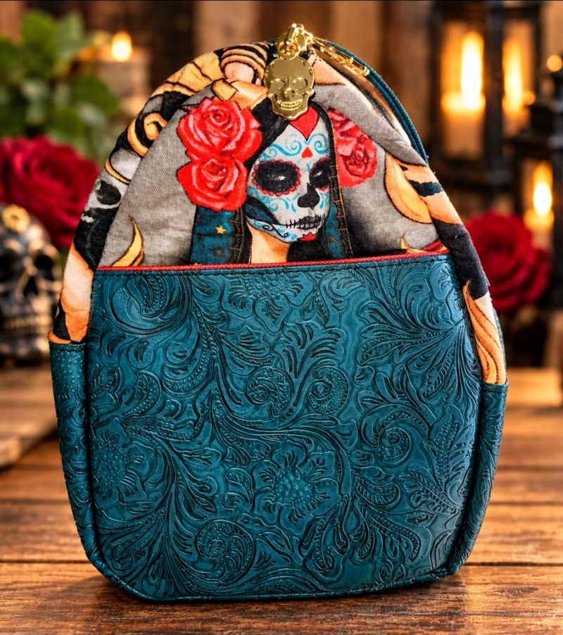 Side view of handmade sugar skull bowler bag with teal floral embossed vinyl